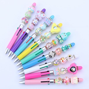 Close-up of DIY beaded ballpoint pens with cartoon charms like butterflies and cupcakes
