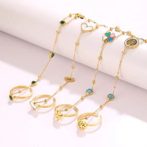 Details von vergoldeten Edelstahl-Ringarmbändern mit Kleeblatt- und Herzanhängern