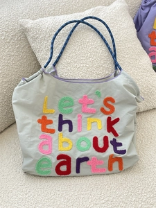 Minimalist light gray canvas tote bag with colorful earth theme embroidery and blue straps