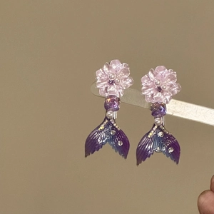 Close-up detail of aesthetic purple mermaid tail hair clips with pearl flower ornaments