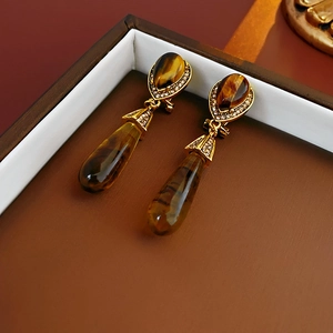 Macro view of vintage teardrop tiger eye earrings with sparkling diamond accents