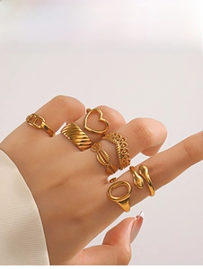 Close-up of 7-piece gold heart and snake ring set worn on hand with detailed textures