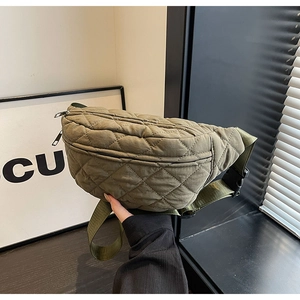 Close-up of military green quilted chest bag featuring dual zippers and durable webbing strap
