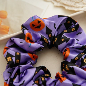 Detail of purple satin Halloween scrunchie with pumpkin, castle and bat pattern prints
