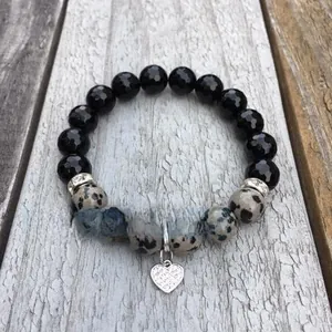 Handmade beaded bracelet with black faceted beads, spotted stones and heart charm