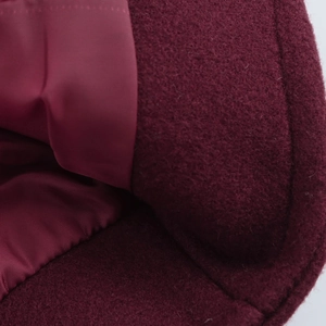 Macro view of burgundy wool blend coat with smooth satin lining and stitching details
