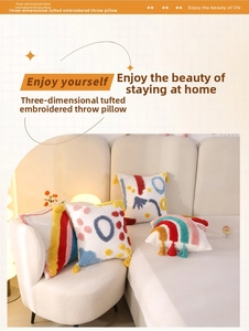 Detail of colorful tufted rainbow pillows with tassels and 3D embroidery texture