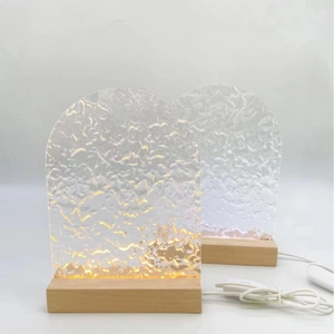 Détail de la veilleuse en acrylique à effet d'eau sur socle en bois avec deux couleurs de lumière