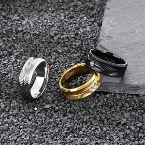 Detailed view of feather engraved stainless steel rings with round zirconia in three colors