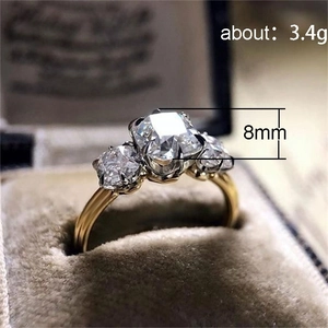 Vintage driestenen gouden ring met vierkante zirkonia in een luxe fluwelen sieradendoos
