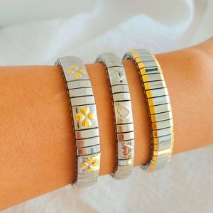 Three-piece stainless steel charm bracelets featuring clover and heart motifs on a model's wrist
