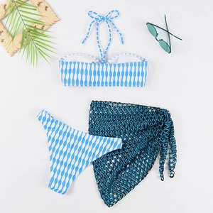 Vue à plat d'un bikini à rayures bleues avec un paréo en résille noire et feuilles de palmier