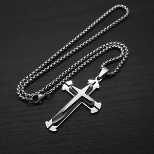 Detailed view of silver stainless steel triple-layered cross pendant with a box chain
