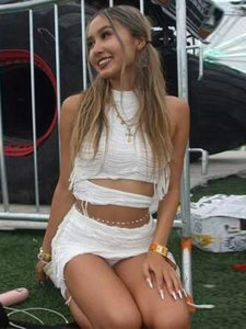 Completo bianco con crop top allacciato al collo e minigonna con frange in maglia