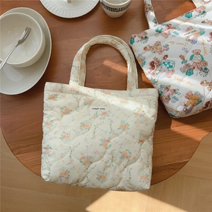 Détails de sacs fourre-tout matelassés à motifs floraux et d'ours, texture moelleuse