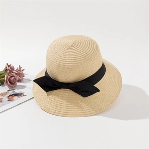 Detail eines beige Strohhuts für Damen mit einer eleganten breiten schwarzen Schleife