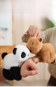 Detailed view of plush red panda and capybara slap bracelets worn on a wrist