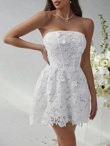 Detail of white lace mini dress showing 3D floral textures and strapless slim fit design