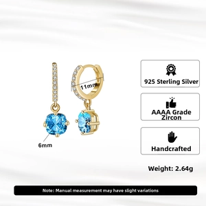 Detail of 925 sterling silver gold earrings with square blue zircon and pavé setting