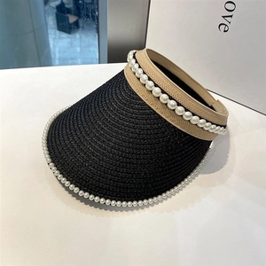 Detail of black woven sun visor featuring elegant white pearl trim and beige ribbon strap