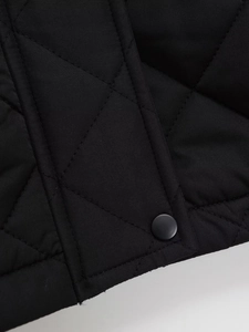 Detailaufnahme der Rautensteppung und des mattschwarzen Druckknopfs der Damenjacke