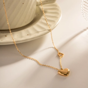 Detail of 18K gold-plated double heart pendant on a delicate cable chain necklace