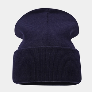 Detail of dark blue ribbed knit beanie showing high-quality wool blend texture and fold