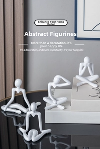 Set of four minimalist white abstract figurines displayed on books for home decor