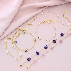 Golden flower petal beaded bracelets and necklaces for women on pink fabric
