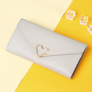 Detail of light grey long wallet featuring a gold heart ornament and textured PU leather