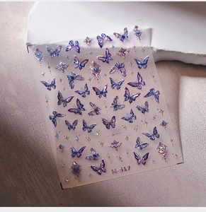 Detailed macro view of laser holographic butterfly nail stickers in blue and purple hues