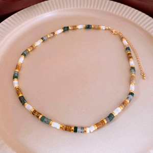 Detailed view of colorful floral ceramic bead necklace displayed on a ceramic plate