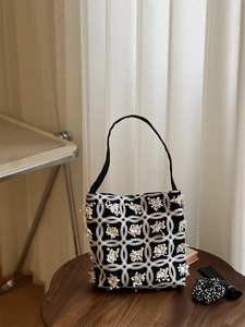 Close-up of vintage geometric pattern canvas bag with 3D fringe flower details