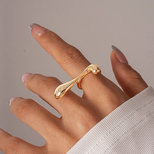 Detail of liquid-style polished gold irregular geometric ring on a model finger