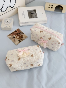 Detailed shot of quilted bear pattern makeup bags with pink bows and lace trim decoration