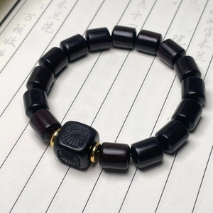 Détail du bracelet en bois de santal avec perle carrée gravée et entretoises dorées