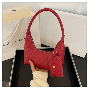 Close-up of a red woven texture handbag featuring a matching small coin purse attachment
