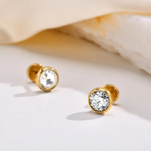 Macro detail of gold stainless steel stud earrings with round brilliant cubic zirconia stones