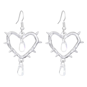 Macro view of gothic thorn heart earrings with clear teardrop charms on white backdrop