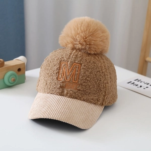 Close-up of baby teddy fleece baseball cap with pompom and M BABY embroidery detail