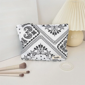 Macro detail of canvas paisley makeup bag showing zipper closure and textured floral fabric