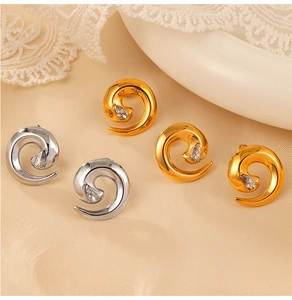 Close-up of spiral twisted earrings in gold and silver with sparkling inlaid crystals
