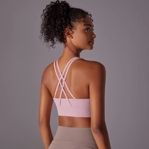 Dettaglio del reggiseno sportivo rosa chiaro con spalline incrociate e tessuto tecnico