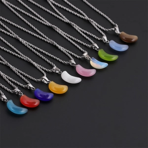 Detail of colorful crescent pendants with silver twist chains on a dark background