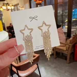 Detail of S925 silver star earrings with gold plating and sparkling crystal tassels