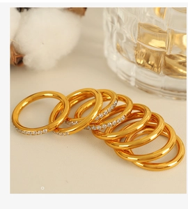 Detail of stacked gold plated rings with cubic zirconia and minimalist polished bands