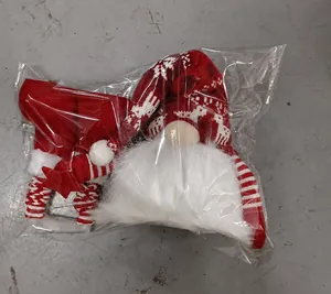 Close-up of the red and white Christmas gnome plush toy in its transparent packaging