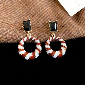 Macro shot of vintage style earrings featuring black gemstone and striped round pendant