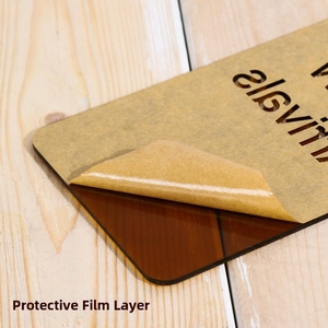 Detalle de placa acrílica transparente con película protectora marrón retirada