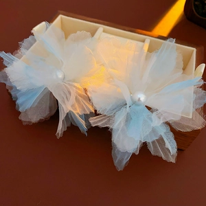 Detail of white tulle flower necklace with pearl center in a wooden jewelry box